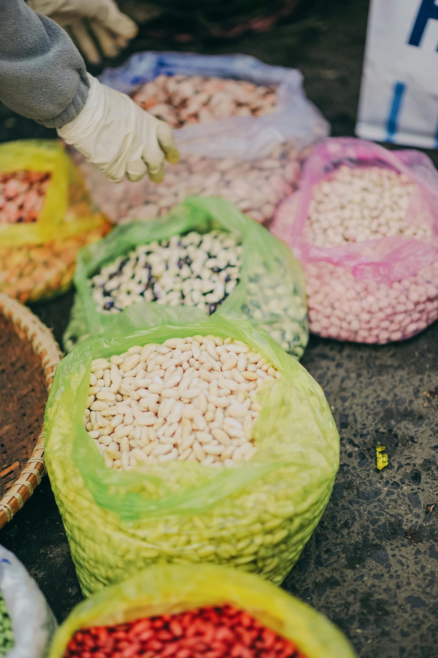 Colorful sacks of organic beans and legumes in a vibrant market setting.